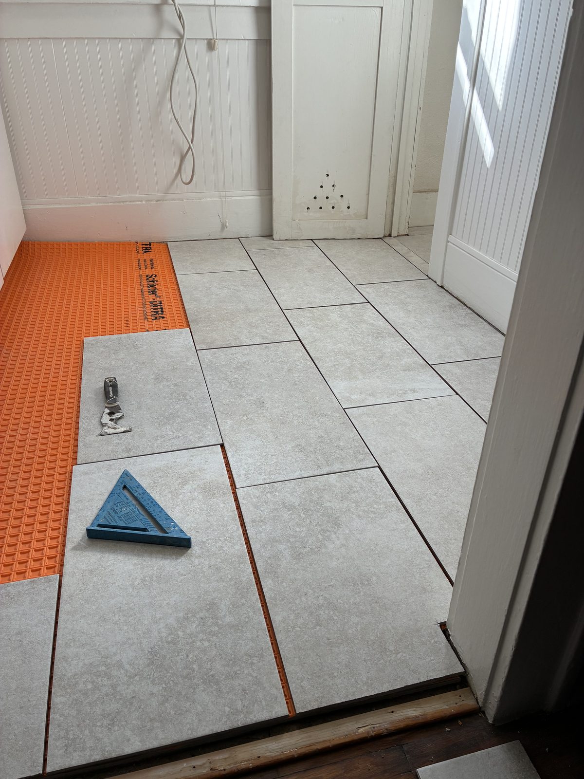 Bathroom tile floor installation in progress