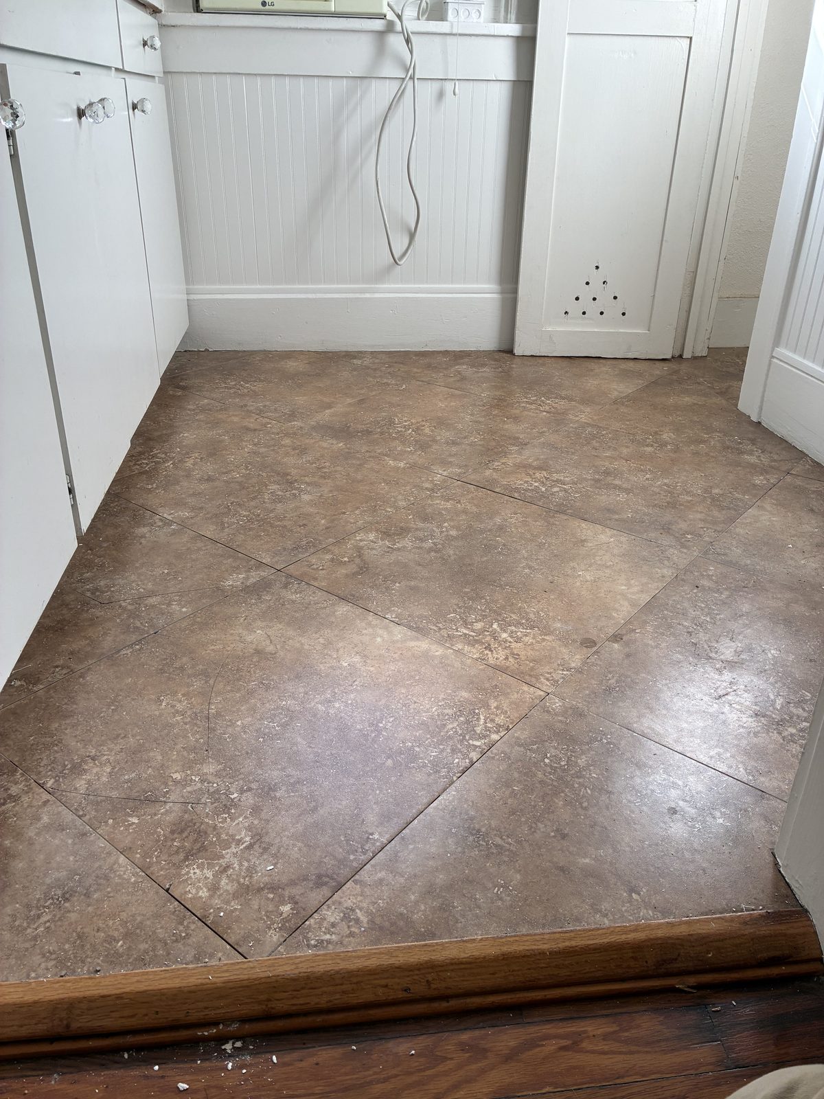 Large format tan tile floor installation