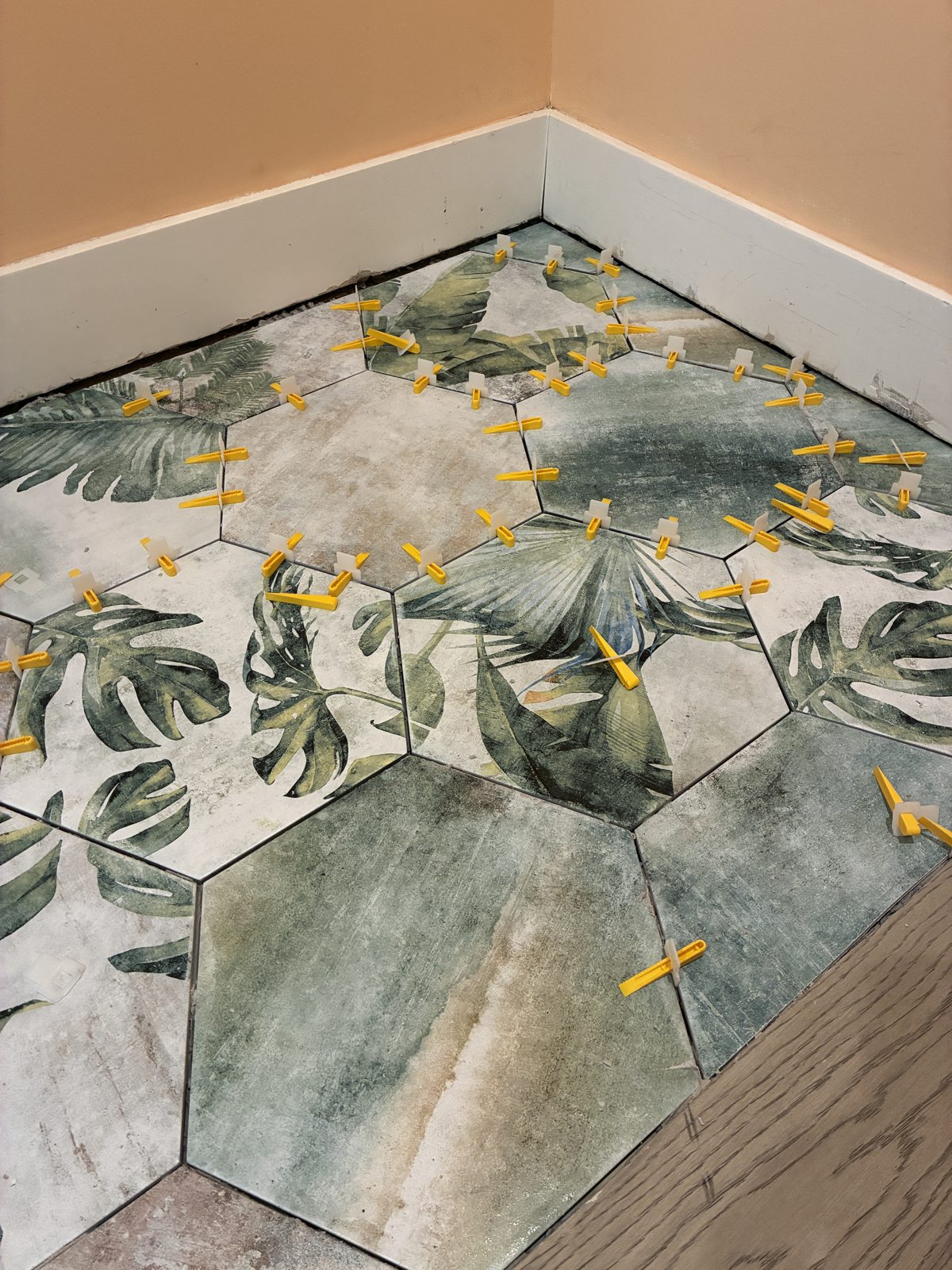 Botanical hex tile floor installation in progress with leveling clips Austin TX